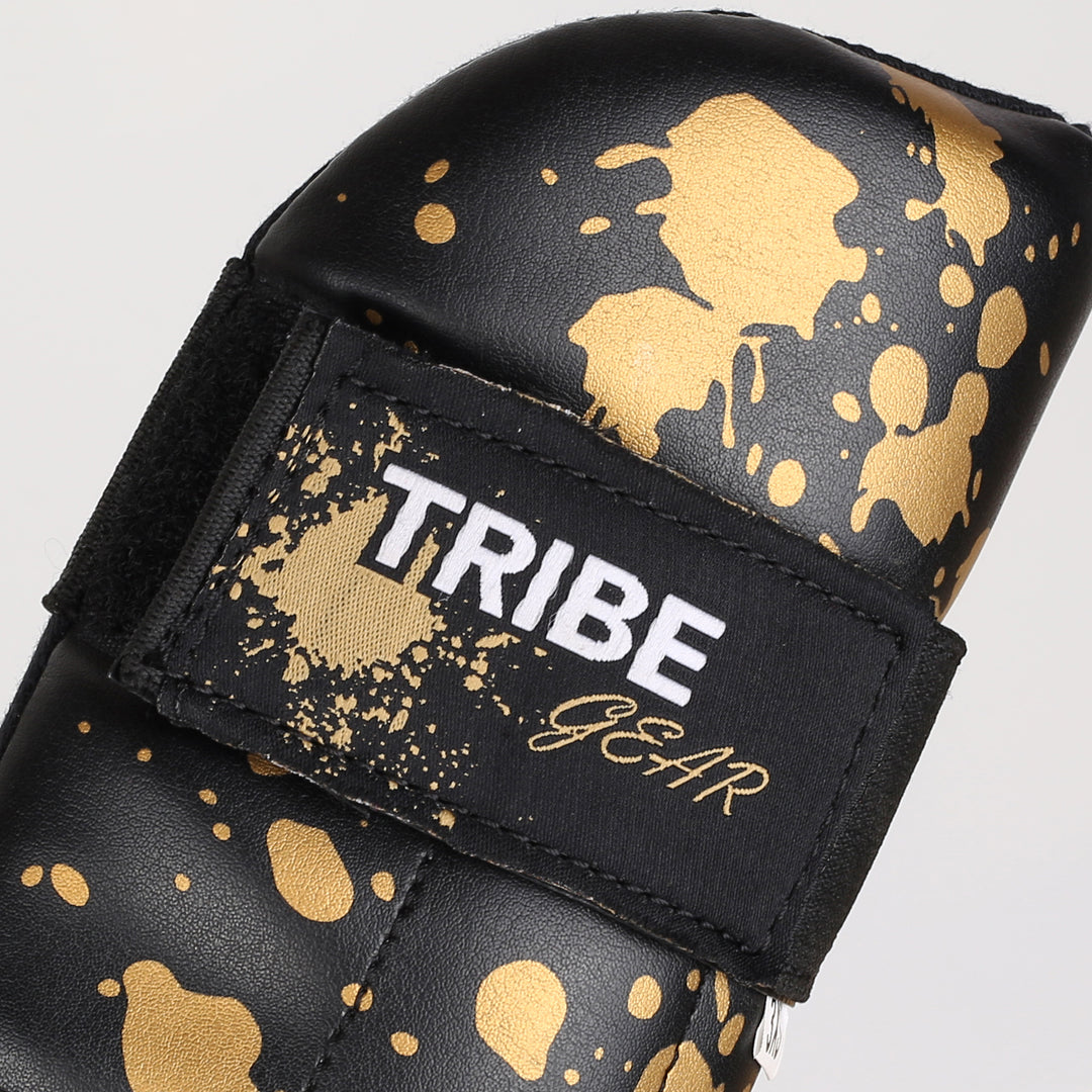 TribeGear logo op goud splash kickboksen scheenbeschermers detail