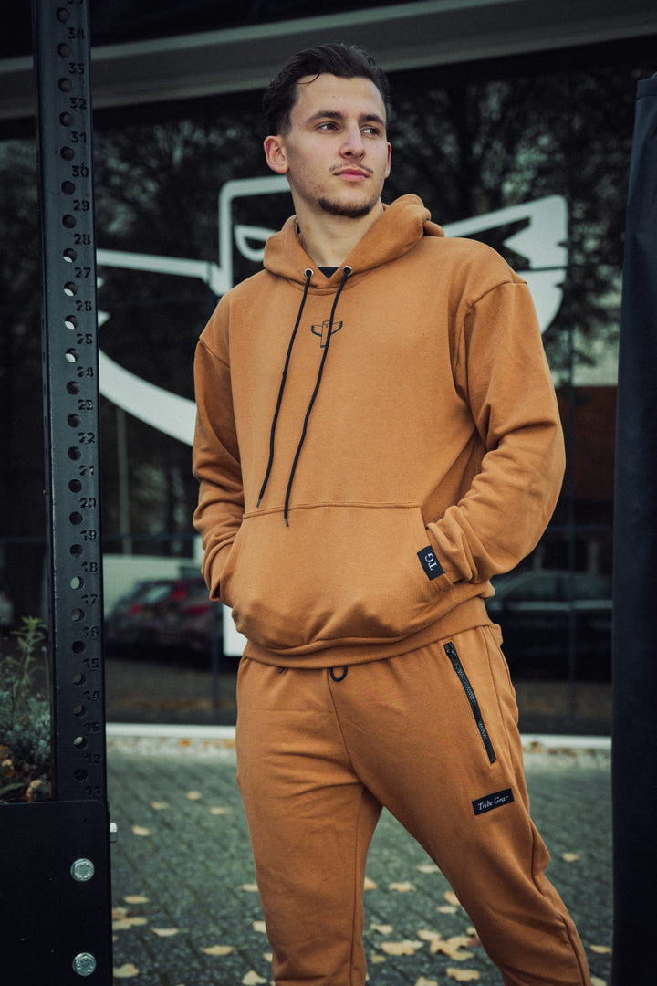 Bruine TribeGear hoodie en jogger sportset gedragen bij kickboks training buiten 🥊