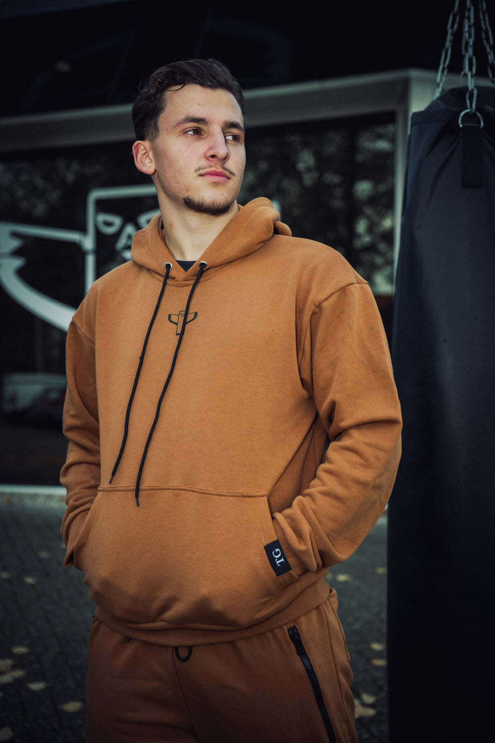Bruine TribeGear hoodie gedragen tijdens kickboks training bij bokszak