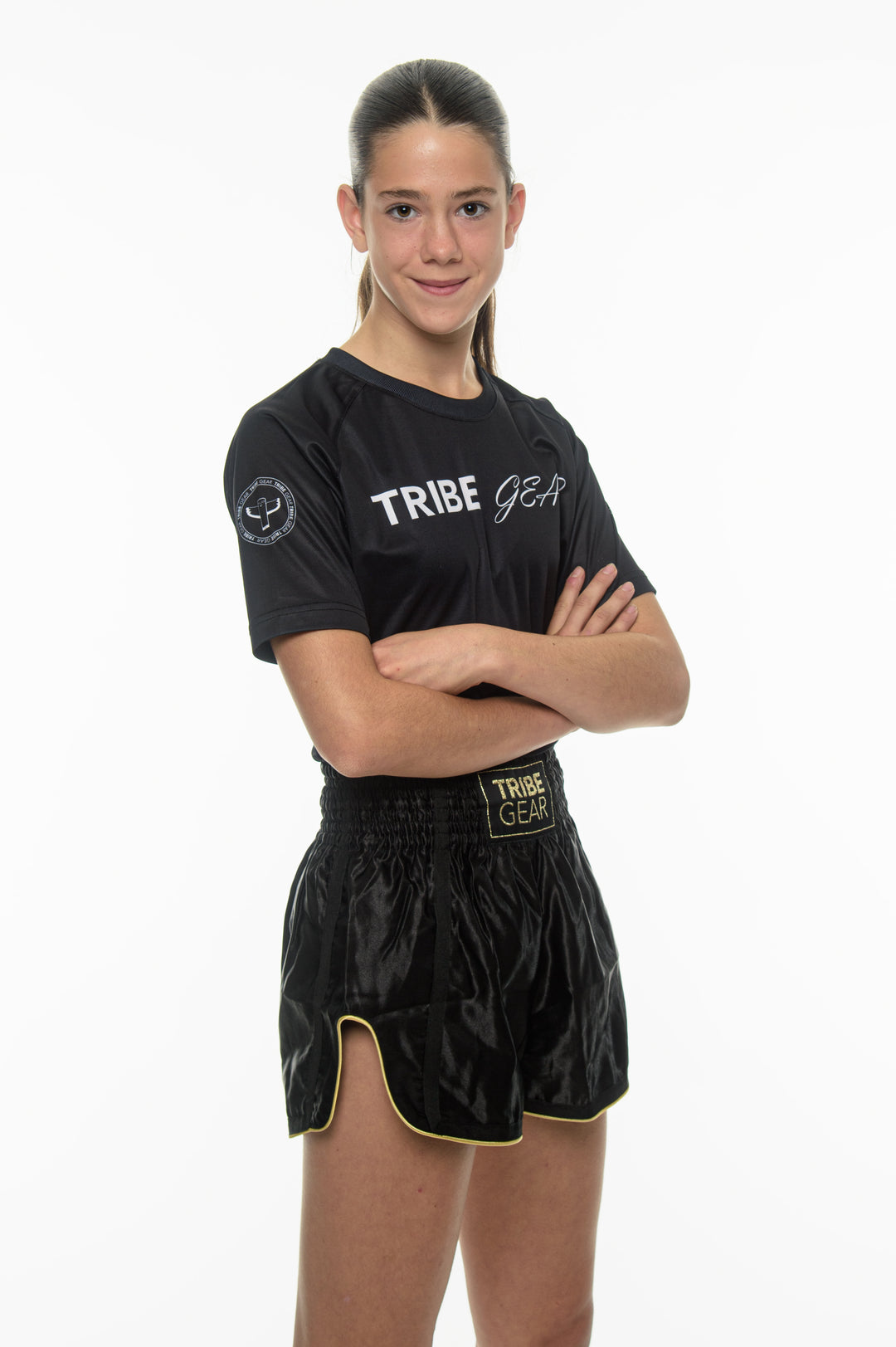 Dames kickbokser draagt zwarte TribeGear muay thai shorts en training shirt voor kickboksen