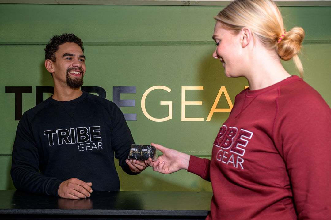 Klant rekent aankoop af bij balie van TribeGear winkel voor kickboks kleding en gear